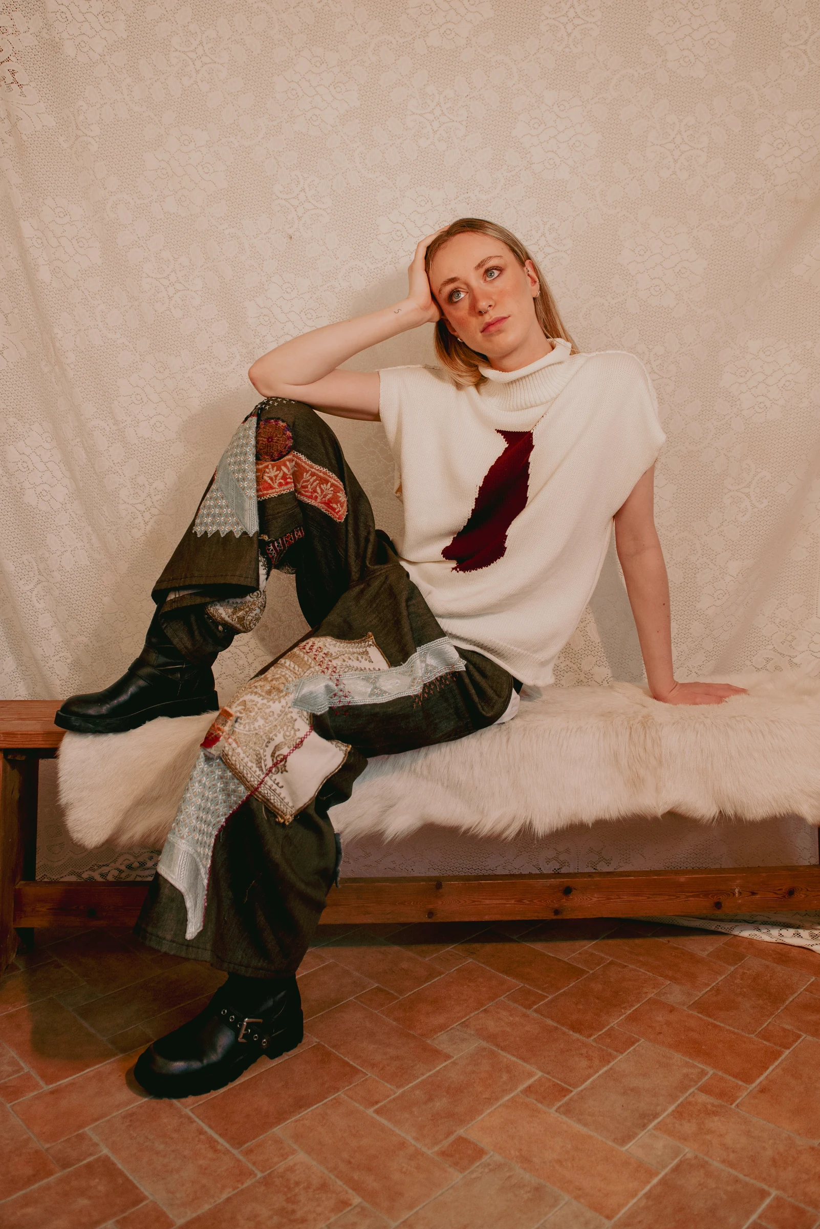 Look 4 — cream sleeveless knit with a burgundy tie motif and sashiko patchwork jeans