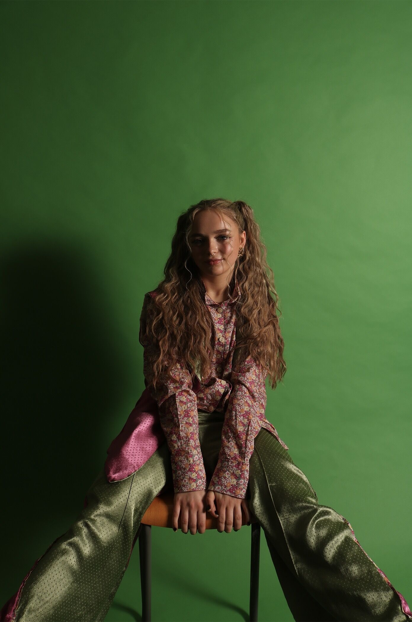 The Modern Dandy — final shoot, seated pose against green backdrop